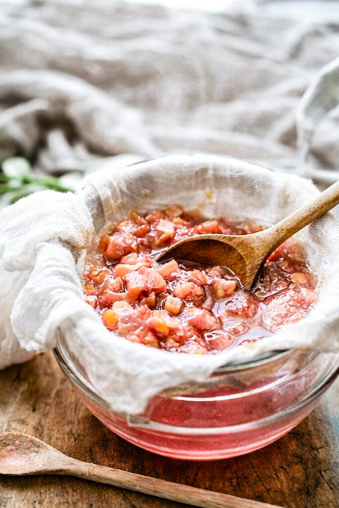 Straining boiled rhubarb with cheesecloth to get out the juice. 