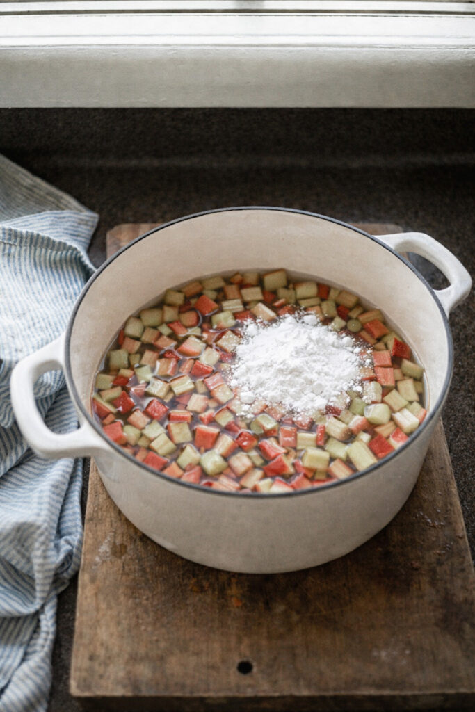 Adding water and cream of tartar to chopped rhubarb to make juice. 