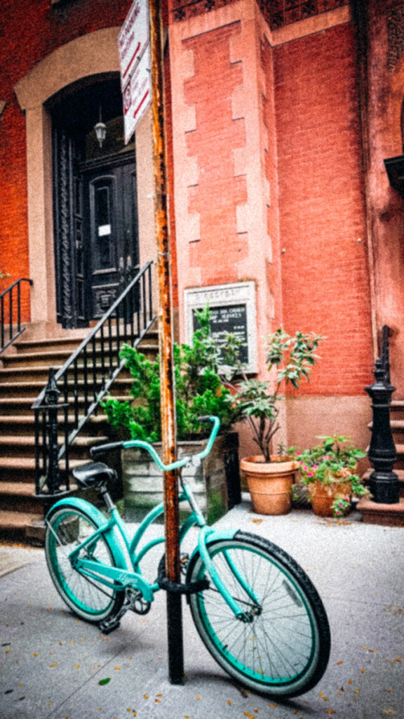 A beautiful vintage bicycle outside of a brick house in NYC.