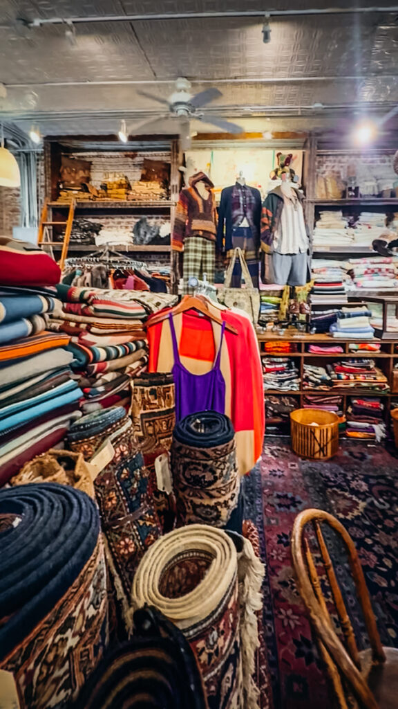 The inside of Stella Dallas Living with a huge selection of antique rugs and vintage clothing.