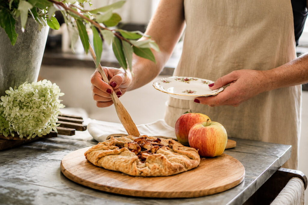 A delicious apple galette that's about to be served on a vintage tea plate. 