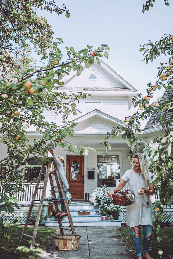Practicing Hygge in autumn in front of a beautiful Victorian house, and Deborah from B Vintage Style picking apples with her daughter