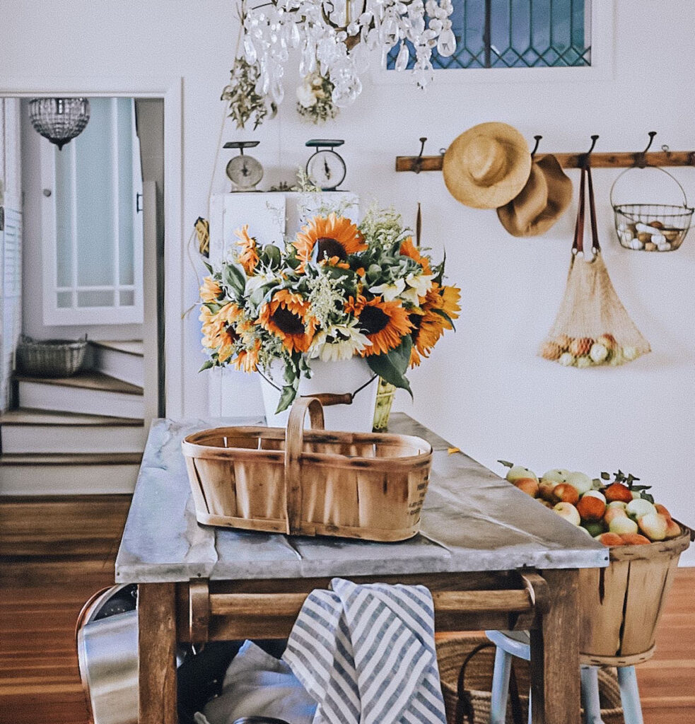 Stunning bouquet of sunflowers on a galvanized top kitchen island with linens and a basket of apples