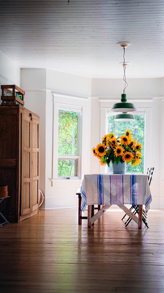 Beautiful arrangement of bright sunflowers on a farmhouse dining room table.