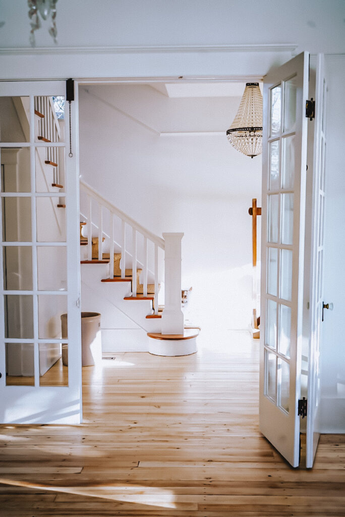 A beautiful antique staircase that's seen through triple French doors in an old Victorian home.