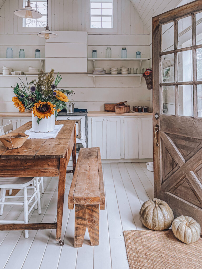 Tiny house cabin with a fall arrangement and beautiful sunflowers on the farmhouse table.